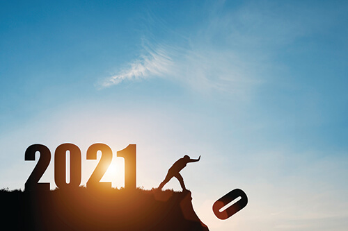 Man push number zero down the cliff where has the number 2021 with blue sky and sunrise. It is symbol of starting and welcome happy new year 2021.