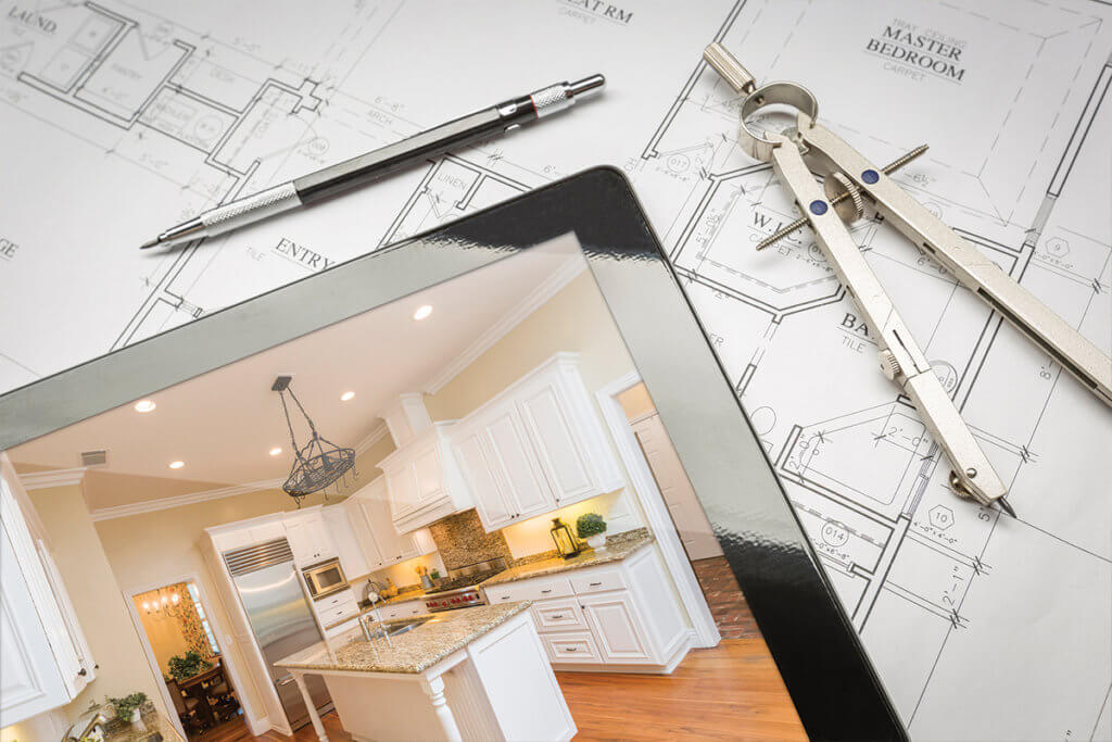 Plan of house with tablet sitting on top with picture of kitchen on screen